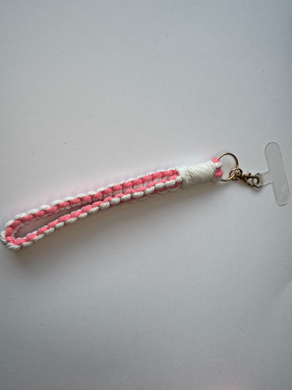 A handmade macaron-style beaded phone charm on its lanyard cord