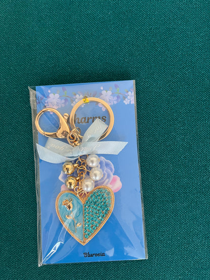 The blue glitter heart charm keyring with pearl and gold-tone accents, on its backing card